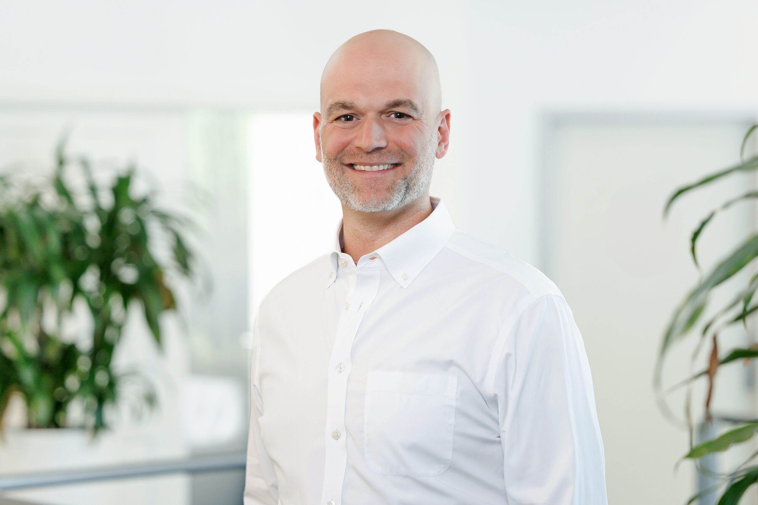 Zu sehen ist Steuerberater und Geschäftsführer der DHW, Christian Deák in einem weißen Hemd.
