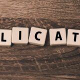 Scrabble-Steine mit dem Wort "Application" – Symbol für die IOSS-Registrierung im internationalen E-Commerce.