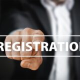 Geschäftsperson tippt auf „Registration“-Symbol als Sinnbild für die Online-OSS-Anmeldung